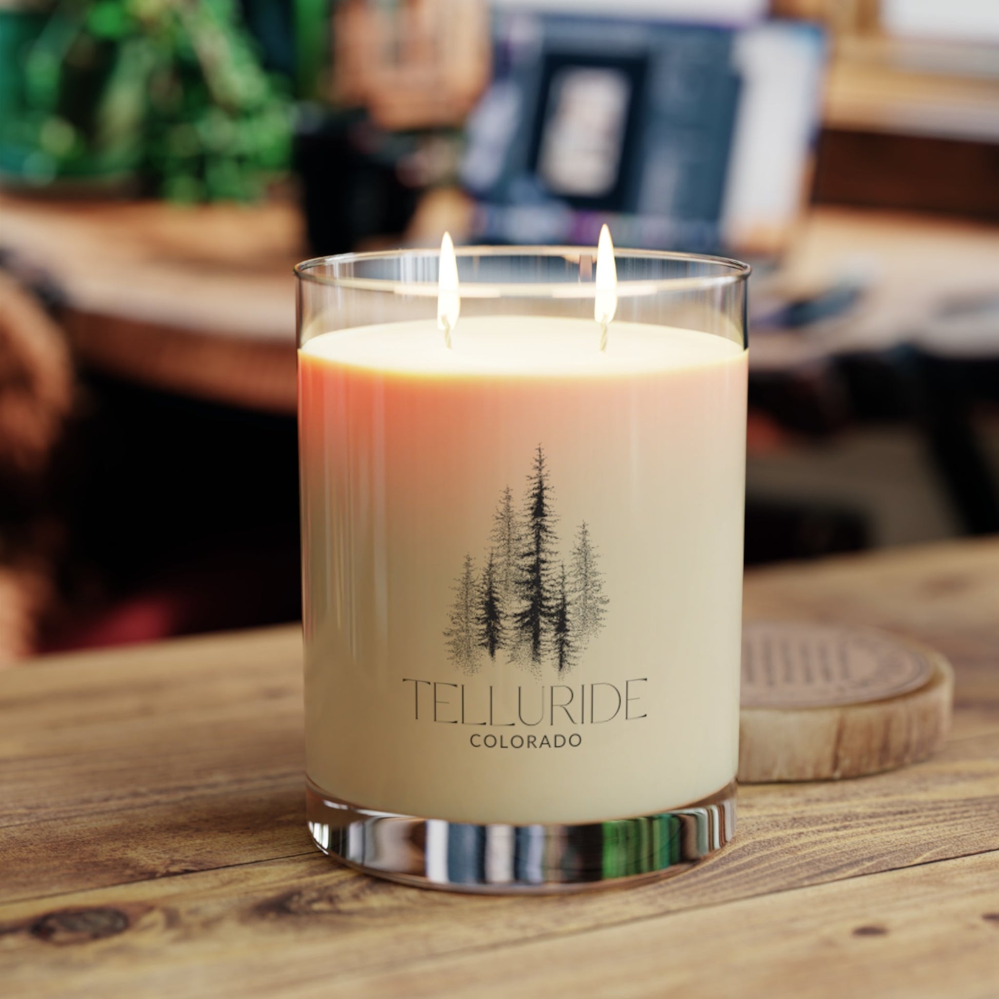  White wax scented glass candle with two wicks and the words "Telluride" and "Colorado" and a picture of trees in black printed on the glass. The candle is a stylish and aromatic way to bring the beauty of Telluride, Colorado and your amazing time at the Telluride Ski Resort into your home.  The candle is a great way to relax and unwind after a long day of skiing, snowboardings, shopping or hiking.